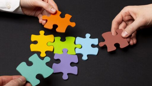 Personas con piezas de un rompecabezas armándolo