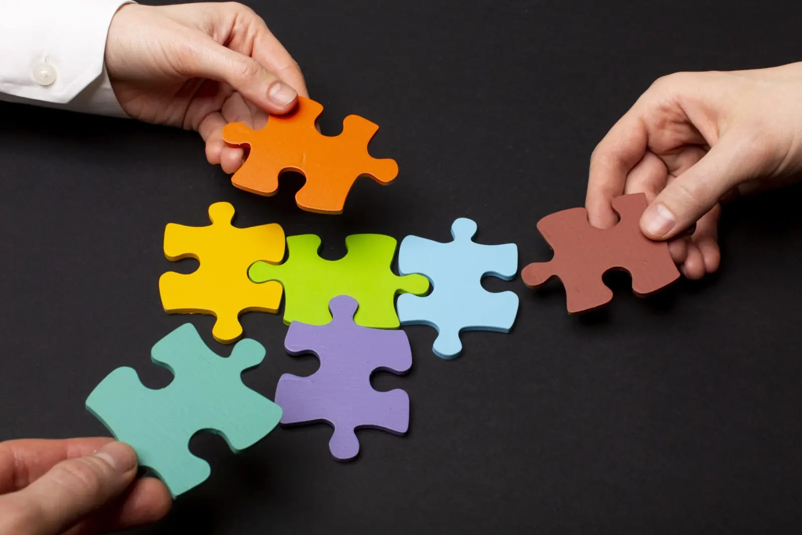 Personas con piezas de un rompecabezas armándolo